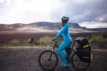 Fototapeta na wymiar Happy biker on backdrop of volcanic mountains in Iceland