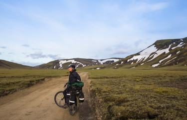Happy biker on backdrop of volcanic mountains in Iceland