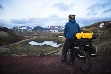 Fototapeta premium Happy biker on backdrop of volcanic mountains in Iceland
