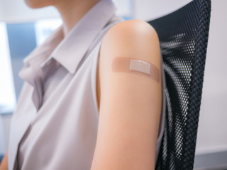 Adhesive bandage on a female arm after vaccination
