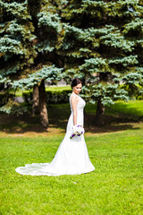 Obraz na płótnie Canvas Beautiful bride in wedding dress and bridal bouquet