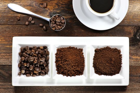 Kaffeebohnen, Kaffeepulver und Instantkaffee auf rustikalem Holztisch