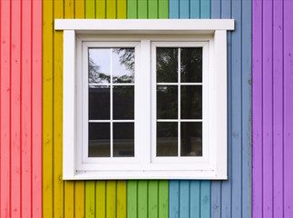 rainbow house. wooden wall of a house painted in a rainbow of colors