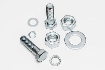 Metal nuts and bolts on white background
