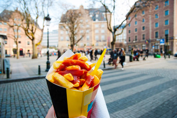 Holding typical belgian fries in hand in Brussels - 89073342
