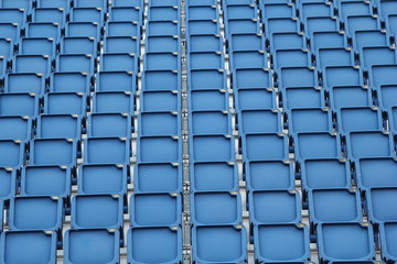 Plastic blue seats on football stadium background