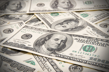 One hundred dollars pile as background.