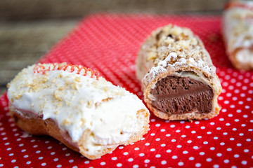 Chocolate and icing topping eclairs with chocolate and vanilla c