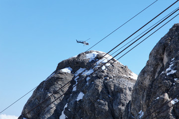 Scenic helicopter flies over the tops of the Marmolada, in front of the rope to the top of the cab....