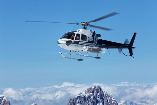 Scenic helicopter flies over the tops of the Marmolada, in front of the rope to the top of the cab. Italy