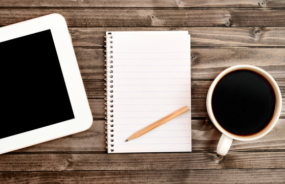 Notepad with tablet and cup of coffee