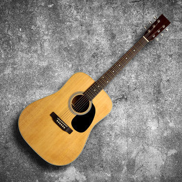 Acoustic guitar on gray wall