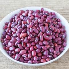 Adzuki bean or red bean in white bowl on wood background