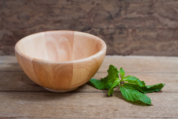 wooden bowl on wooden table over grunge background,