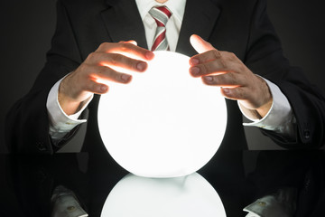 Businessman Predicting Future With Crystal Ball - obrazy, fototapety, plakaty