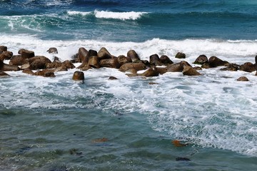 荒波と消波ブロック／山形県の庄内浜で撮影した、荒波を受ける消波ブロックの写真です。消波ブロックは、海岸や河川などの護岸を目的に設置するコンクリートブロックです。海岸沿いに多数のブロックをかみ合わせて並べることで、波のエネルギーを減衰・消散させる事が可能です。また、このブロックにより、水中に複雑で多様な生物生息空間を提供し、円滑な生態系が形成され豊かな水域環境を創り出しています。
