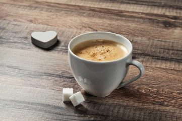 cup of espresso coffee on a wooden table with sugar and wooden heart closeup. Top view. Copy space. Free space for text