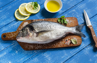 fresh Dorado fish and lemon on a blue wooden background
