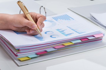 Person Analyzing Graphs At Desk