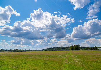 Green meadow under sky with clouds