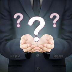 businessman holding question marks
