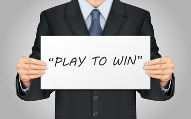 businessman holding play to win poster