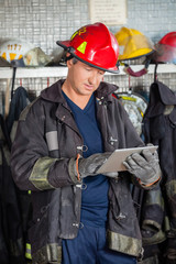 Obraz premium Firefighter Using Digital Tablet At Fire Station