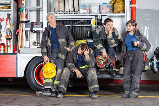 Team Of Tired Firefighters At Station