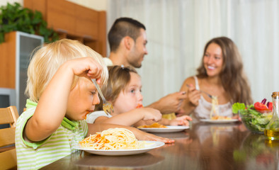 Obraz na płótnie Canvas Family of four eating spaghetti