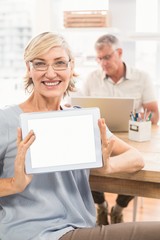 Smiling businesswoman showing her tablet