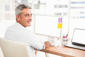 Smiling casual businessman working with computer