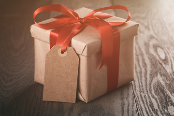rustic present box with red ribbon on wood table