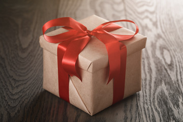 rustic present box with red ribbon on wood table