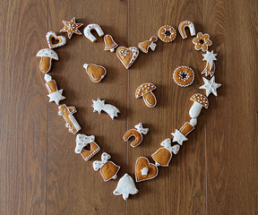 Christmas background with cookies on the wooden board (heart shape frame)