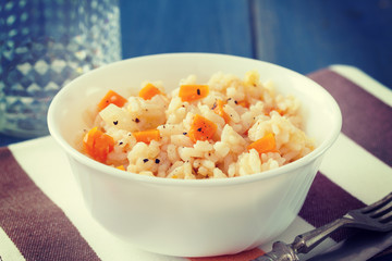 rice with vegetables in white bowl on blue wooden background