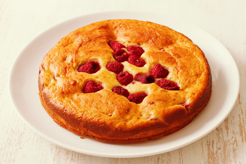 pie with berries on plate on white wooden background
