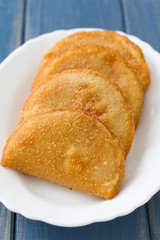 portuguese meat cookies on white dish on blue background