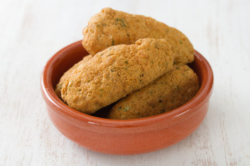 codfish croquettes on dish on white background