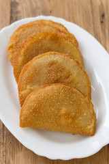portuguese meat cookies on white dish on brown background