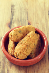 cod fish croquettes on dish on brown background