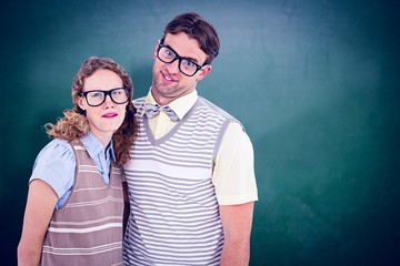 Obraz premium Composite image of happy geeky hipster couple with silly faces
