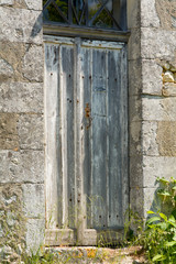 Old battered and damaged wooden door to French home