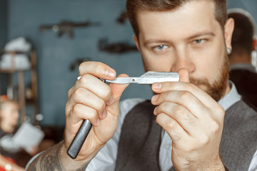 Barber testing the sharpness of a blade