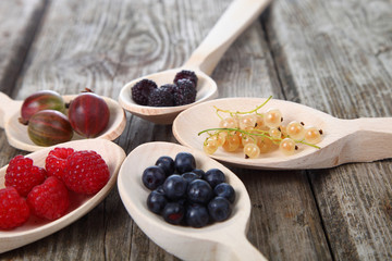 Different ripe berries in a spoons