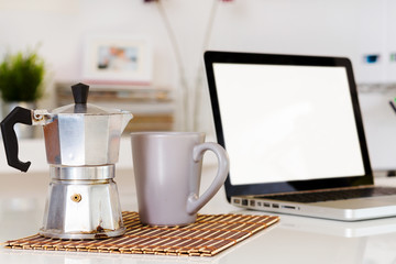 Espresso maker and cup of coffee in a workspace