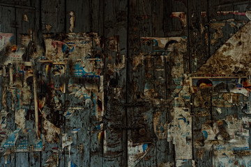 old wooden gate with scraps of classified ads