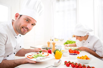 Young attractive professional chef cooking in his kitchen