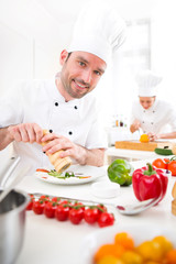 Young attractive professional chef cooking in his kitchen