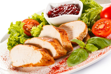 Roast chicken fillet and vegetables on white background 