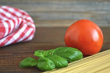 Spaghetti, fresh tomato and basil leaves